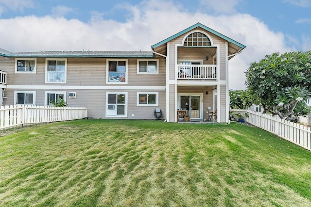 back of house featuring a balcony and a yard