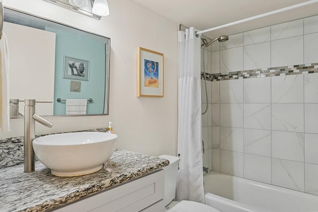 full bathroom with vanity, shower / bath combo with shower curtain, and toilet