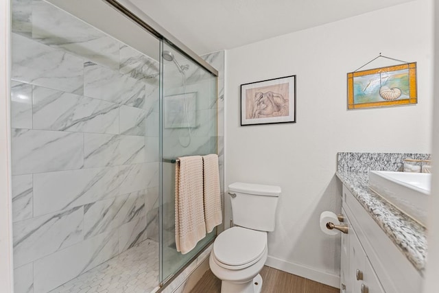 bathroom with wood-type flooring, walk in shower, vanity, and toilet