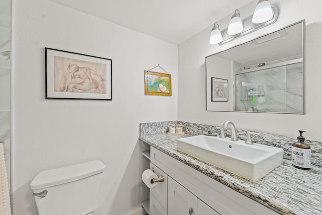 bathroom featuring vanity, toilet, and an enclosed shower