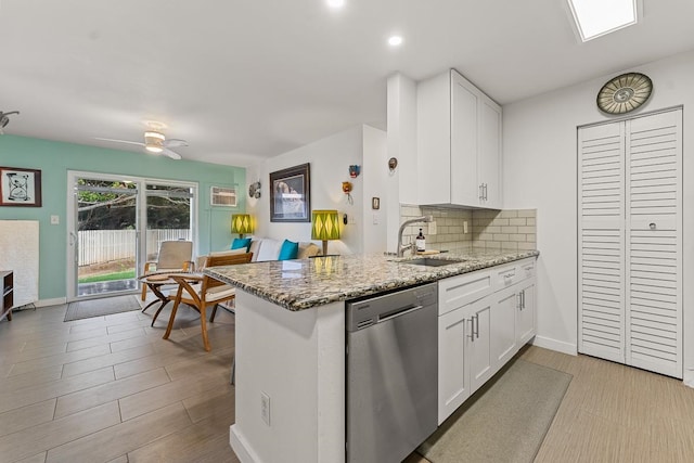 kitchen featuring kitchen peninsula, dishwasher, sink, and white cabinets