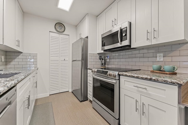 kitchen with appliances with stainless steel finishes and white cabinets