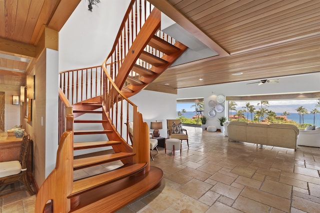 stairs featuring ceiling fan and wood ceiling