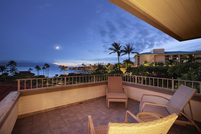 patio terrace at dusk with a balcony and a water view