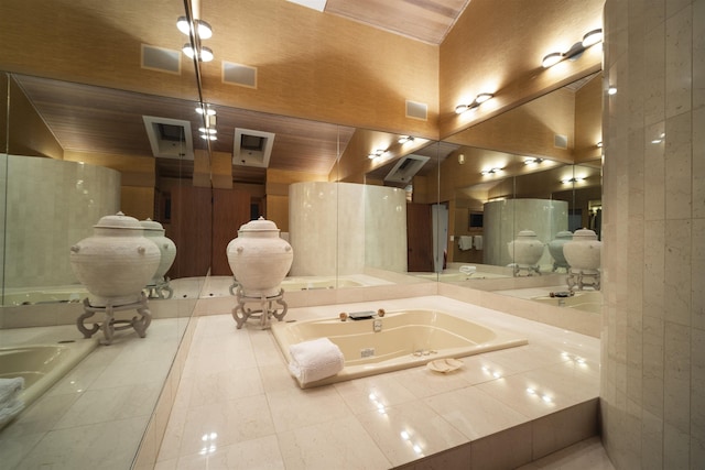 bathroom featuring tile patterned flooring, vaulted ceiling, and tiled tub