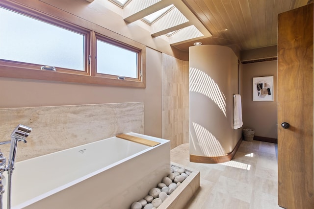 bathroom featuring a bathing tub, wood ceiling, and a skylight