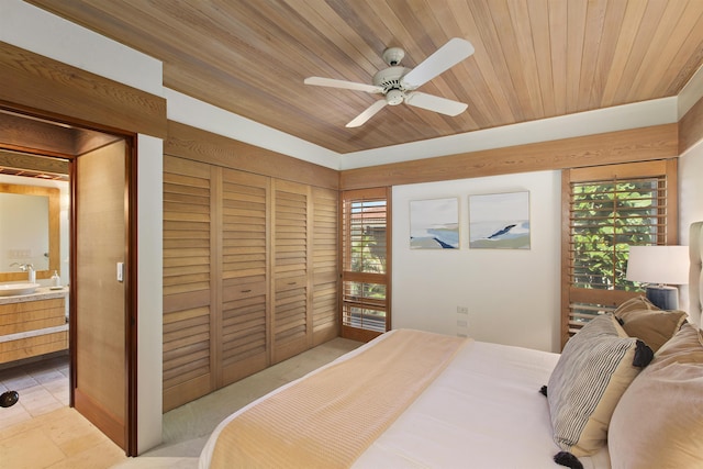 bedroom with a closet, ceiling fan, wooden ceiling, and sink