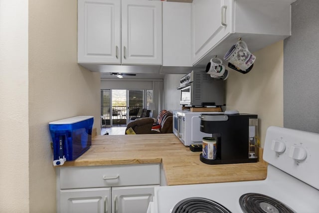 kitchen with ceiling fan, white cabinets, range with electric cooktop, and wood counters