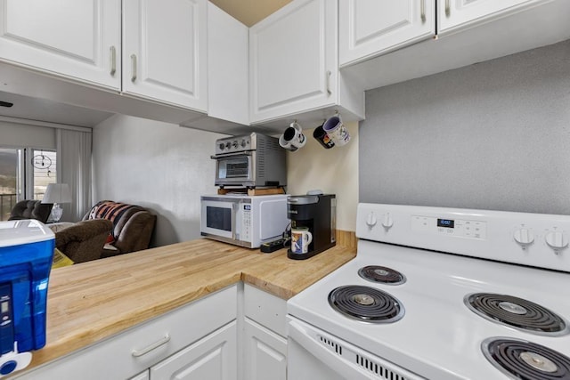 kitchen featuring white cabinetry, butcher block countertops, and white appliances