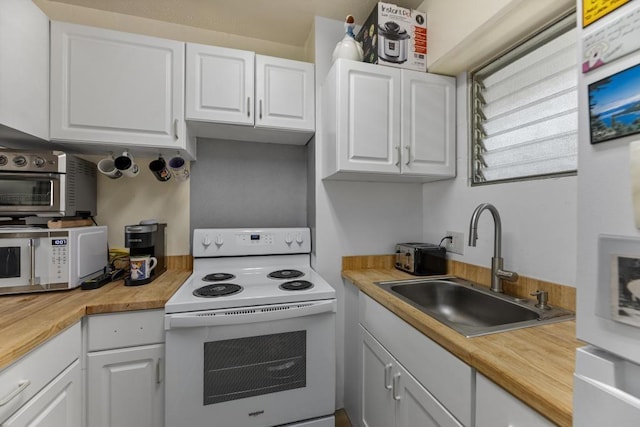 kitchen featuring sink, white appliances, and white cabinetry