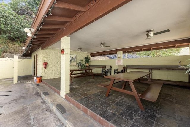 view of patio with ceiling fan and an outdoor bar