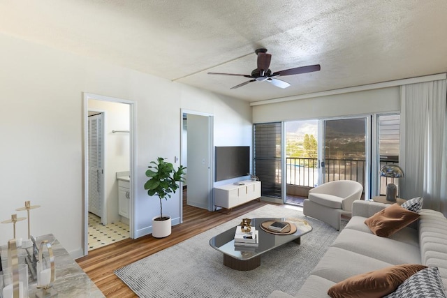 living room featuring hardwood / wood-style flooring, a textured ceiling, and ceiling fan