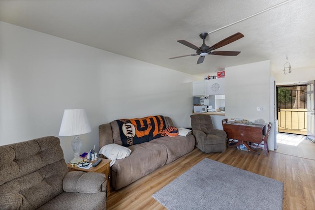 living room featuring ceiling fan and light hardwood / wood-style flooring