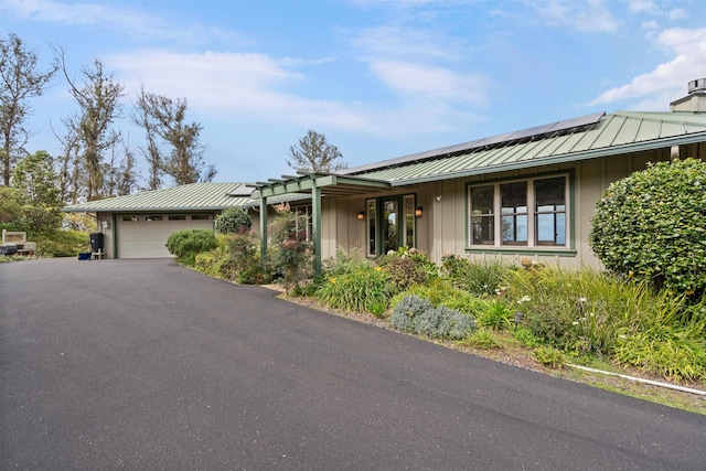 ranch-style house featuring board and batten siding, a standing seam roof, metal roof, and an attached garage