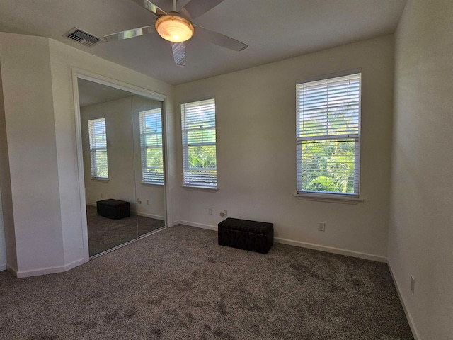 carpeted spare room featuring ceiling fan