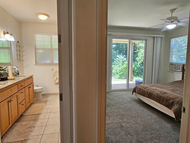 bedroom with cooling unit, light colored carpet, access to outside, ceiling fan, and connected bathroom