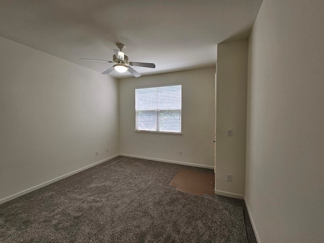 spare room featuring ceiling fan and dark colored carpet