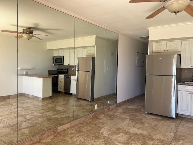 3959 Lower Honoapiilani Rd Unit 304, Lahaina, HI 96761 - kitchen featuring stainless steel appliances, ceiling fan, crown molding, a peninsula, and backsplash