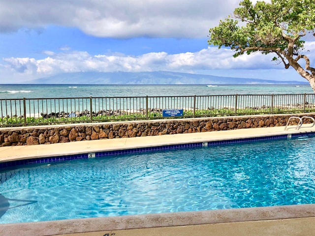 view of swimming pool with a water view