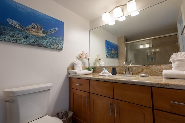 bathroom with vanity, toilet, and a shower with shower door