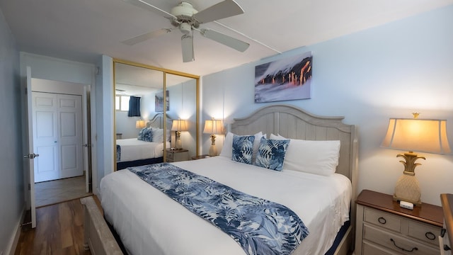 bedroom featuring a closet, dark wood-type flooring, and ceiling fan