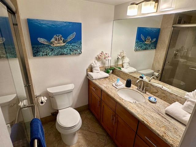 bathroom with tile patterned floors, vanity, toilet, and a shower with door