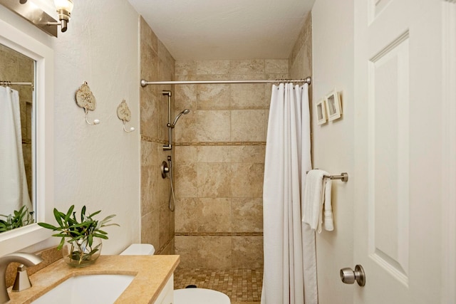 bathroom with toilet, vanity, and walk in shower