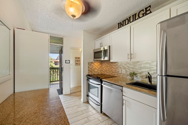 kitchen featuring a textured ceiling, white cabinetry, sink, and stainless steel appliances