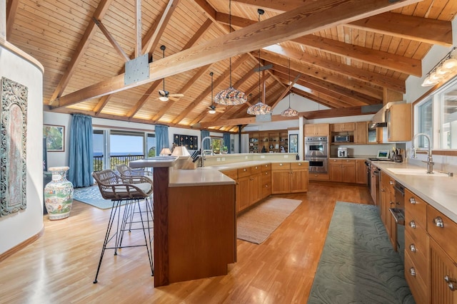 kitchen featuring a sink, wooden ceiling, light wood finished floors, appliances with stainless steel finishes, and light countertops