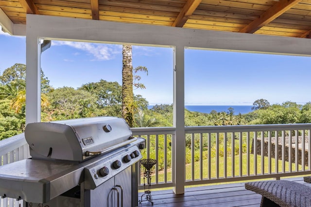 wooden deck with a water view and a grill