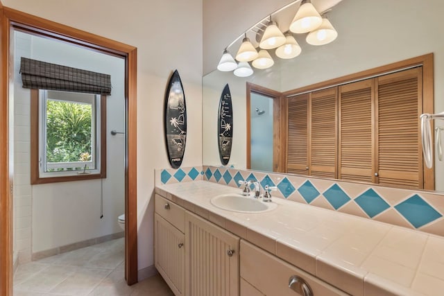 bathroom featuring toilet, tasteful backsplash, vanity, and tile patterned floors