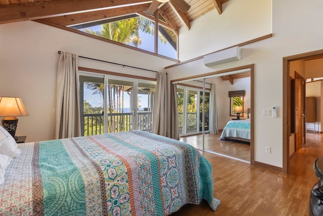 bedroom featuring access to outside, wood finished floors, beamed ceiling, multiple windows, and a wall mounted air conditioner