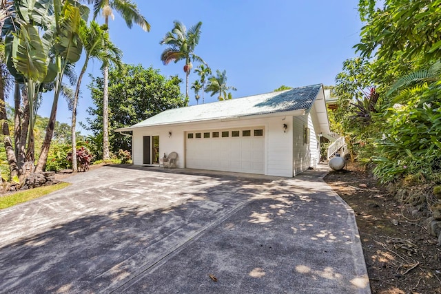 view of side of home with driveway and a garage