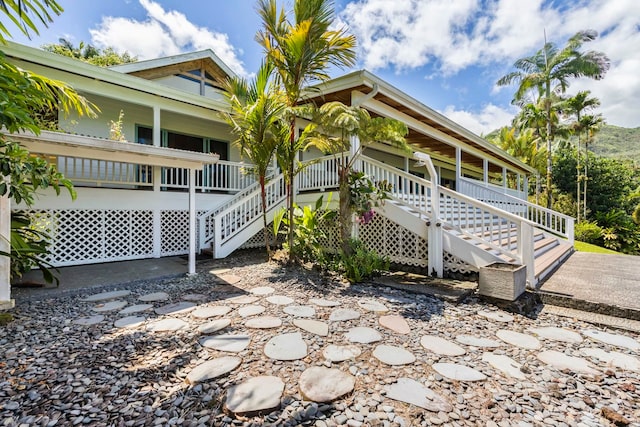view of home's exterior featuring covered porch and stairs
