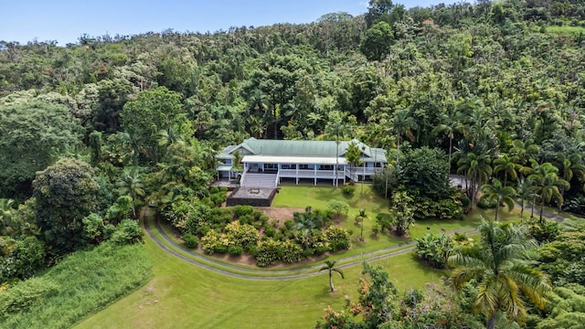 aerial view of property and surrounding area featuring a heavily wooded area