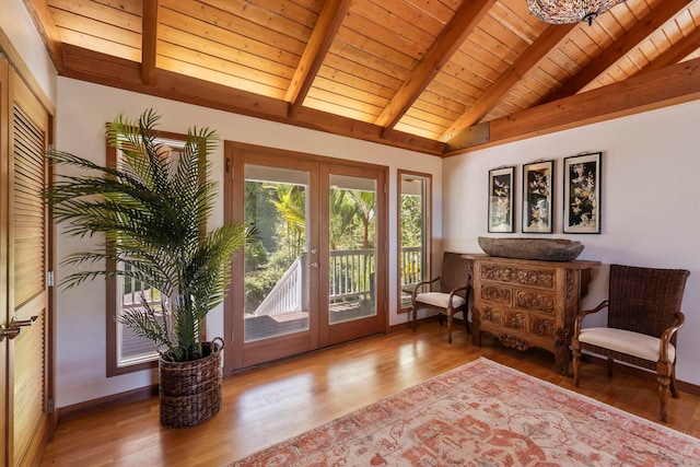 living area with french doors, vaulted ceiling with beams, hardwood / wood-style flooring, and wooden ceiling