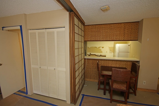 interior space with white fridge and a textured ceiling