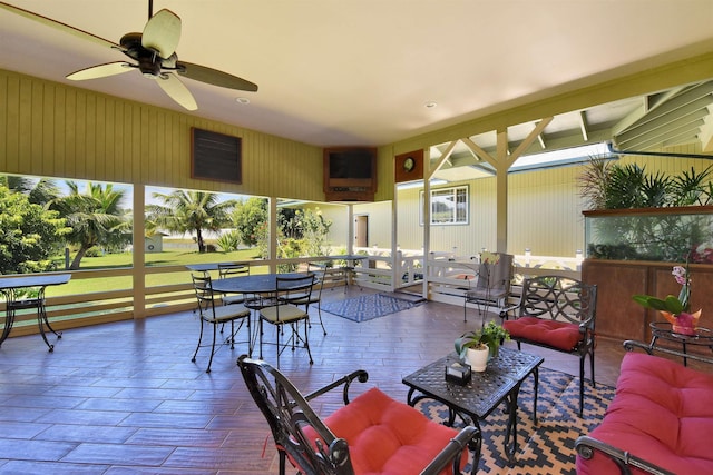 sunroom / solarium featuring a ceiling fan