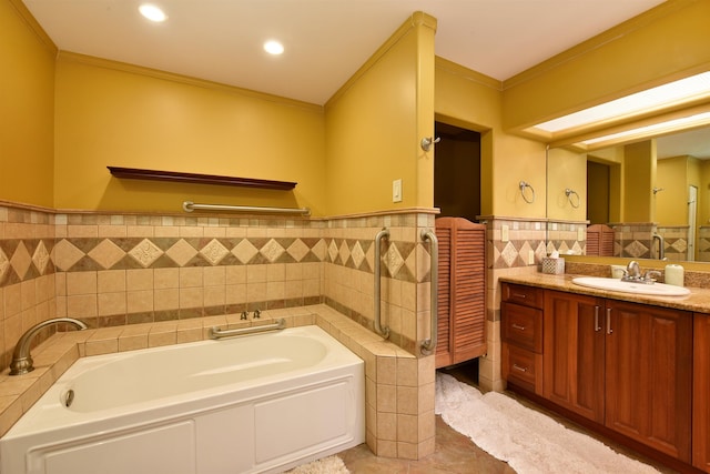 full bath featuring tile walls, vanity, a garden tub, and ornamental molding