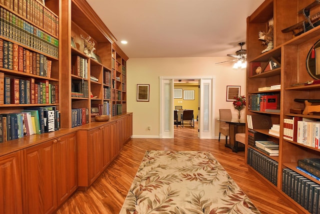 office space featuring baseboards, light wood-type flooring, and ceiling fan