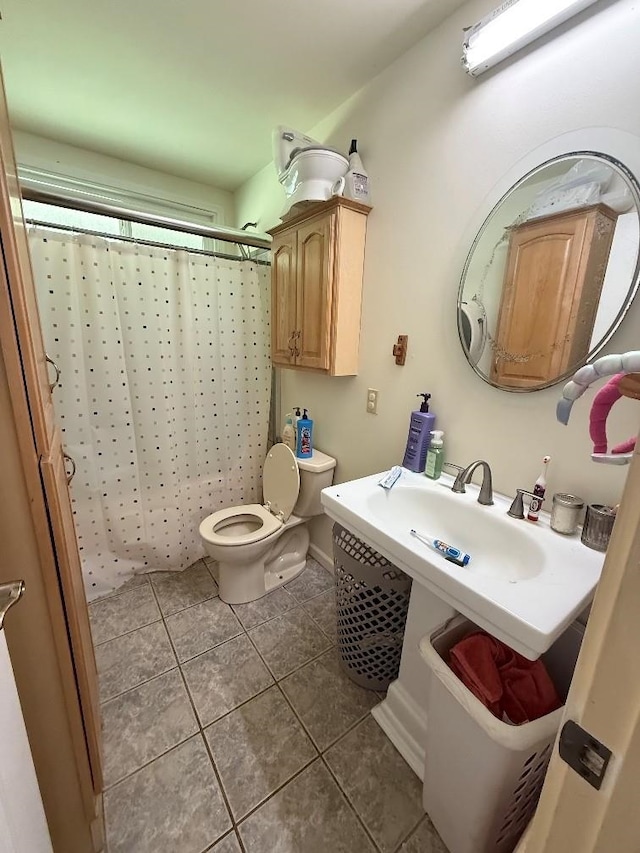 bathroom with tile patterned flooring, toilet, and a shower with curtain