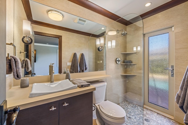 bathroom with toilet, vanity, and tiled shower