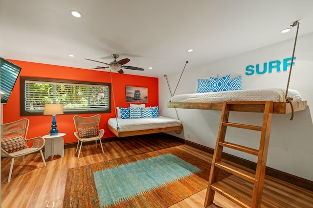 living area with wood-type flooring and ceiling fan