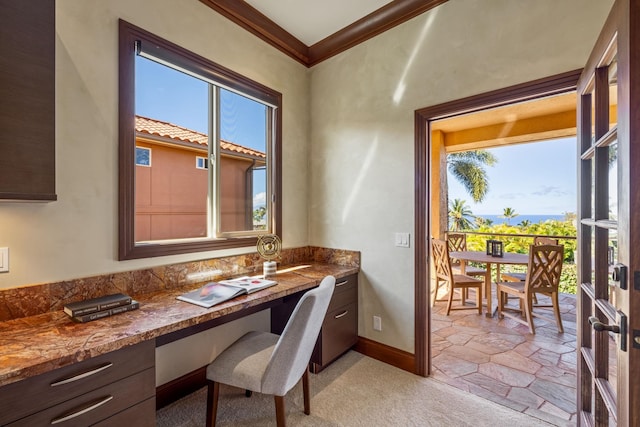 office area with built in desk, ornamental molding, and a wealth of natural light