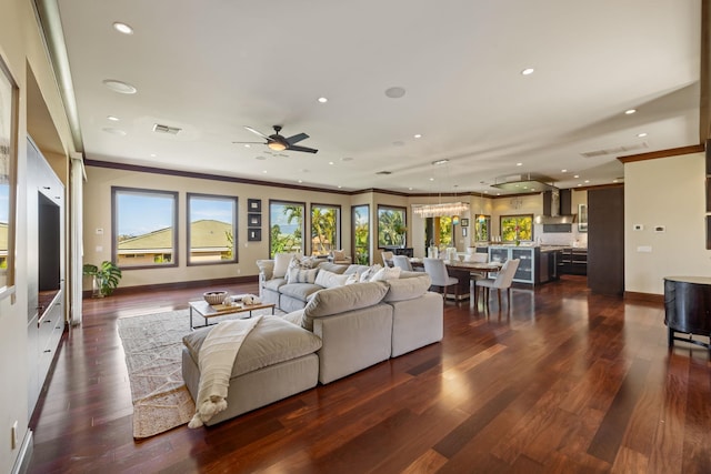 living room featuring ceiling fan, ornamental molding, and dark hardwood / wood-style floors