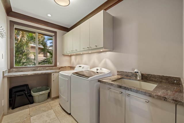 washroom with sink, washing machine and dryer, and cabinets