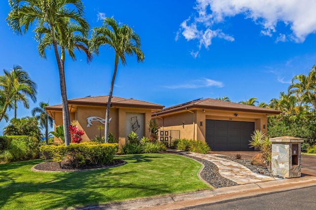 view of front of house featuring a front lawn and a garage