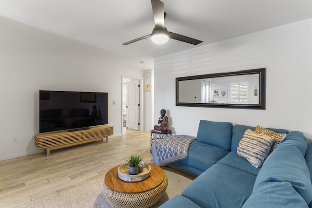 living area featuring ceiling fan, baseboards, and wood finished floors