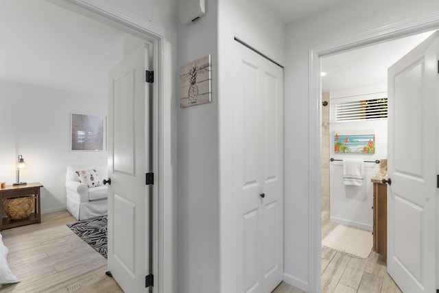 hallway featuring light wood-style floors and baseboards