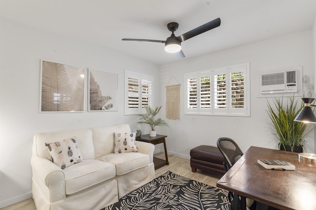 living area with a wall unit AC, wood finished floors, a ceiling fan, and baseboards